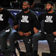 LeBron James and Anthony Davis kneel with teammates before the 2020 NBA Finals.